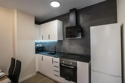 a kitchen with white cabinets and a stove top oven at PLAYA SUITES a 50 metros de la playa in Puerto de Sagunto