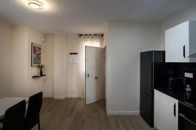 a kitchen with a black refrigerator and a door at PLAYA SUITES a 50 metros de la playa in Puerto de Sagunto