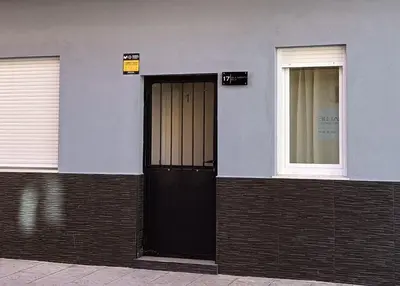 a building with a black door and two windows at PLAYA SUITES a 50 metros de la playa in Puerto de Sagunto