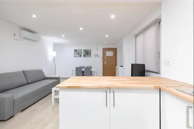 a kitchen with white cabinets and a gray couch at Barraca Breeze in Valencia