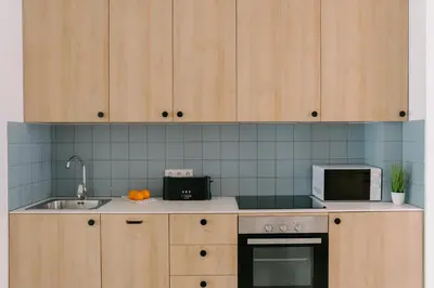 a kitchen with wooden cabinets and a sink and a microwave at Coliving La Alfareria in Valencia