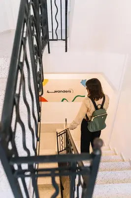 a woman walking down stairs with a sign on the wall at Coliving La Alfareria in Valencia
