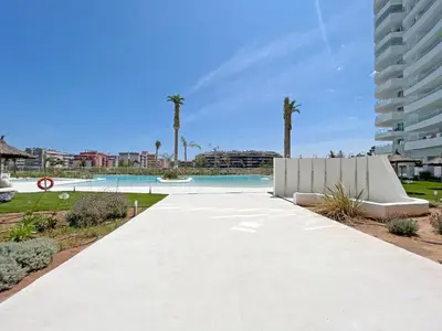 a walkway leading to a pool with palm trees at Global Vacacional, Nuevo apartamento con piscina privada y terraza con vistas al mar in Canet de Berenguer
