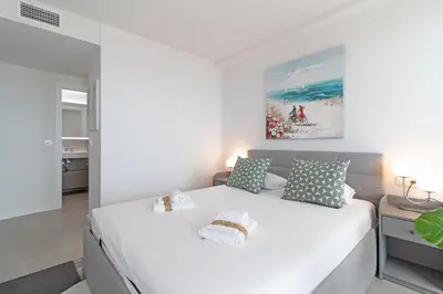 a bedroom with a large white bed with two pillows at Global Vacacional, Nuevo apartamento con piscina privada y terraza con vistas al mar in Canet de Berenguer