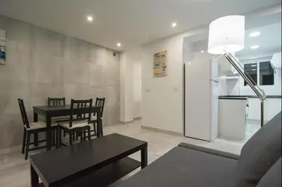 a living room with a table and chairs and a kitchen at Despuig Delight in Valencia