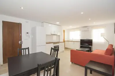 a kitchen and living room with a table and a couch at Relaxing Reina in Valencia