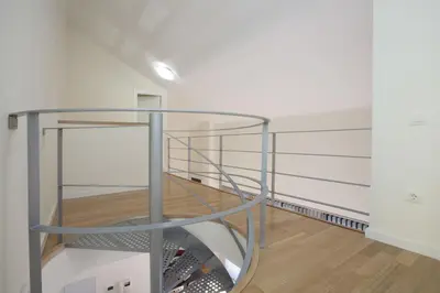 a glass spiral staircase in a room with white walls at SingularStays Comedias in Valencia