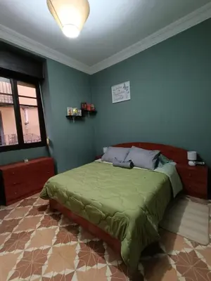 a bedroom with a green bed in a room at Plaça de l'Almudí, where else! in Onda
