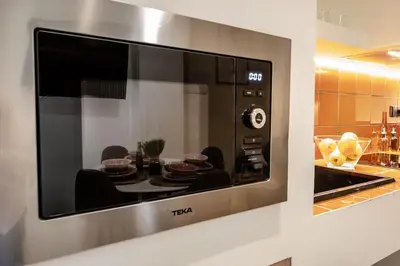 a television on a wall with a table and chairs at Suite de lujo estilo mediterráneo in Valencia