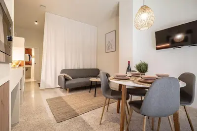 a dining room and living room with a table and chairs at Suite de lujo estilo mediterráneo in Valencia