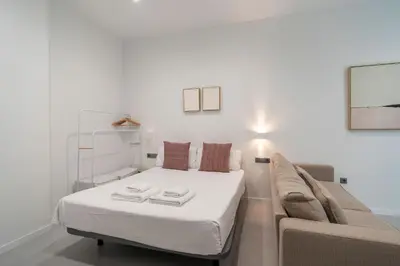 a small bedroom with a bed and a couch at VLC HOST - Bellvis in Valencia