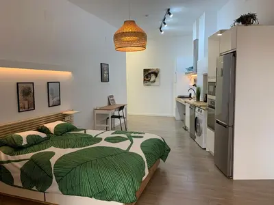 a bedroom with a large bed with green leaves on it at Luna y Sol in Valencia