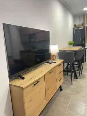a large flat screen tv on a wooden entertainment center at UIM Mediterraneo Estudio PB San Jose Wifi in Puerto de Sagunto