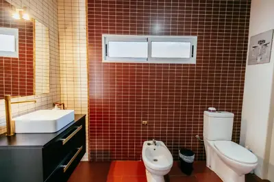 a bathroom with a toilet and a sink and red tile at Casa Pancho, ChillOut, Oceanographic, City of Arts in Valencia