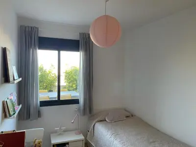 a small bedroom with a bed and a window at Excelente ático con gran terraza y barbacoa en Canet d'en Berenguer in Valencia