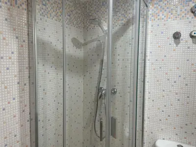 a shower with glass doors in a bathroom at Excelente ático con gran terraza y barbacoa en Canet d'en Berenguer in Valencia
