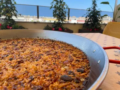 a pan of food sitting on a table at Excelente ático con gran terraza y barbacoa en Canet d'en Berenguer in Valencia