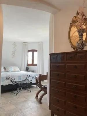 a bedroom with a bed and a dresser and a mirror at Villa Torre Macastre, Valencia in Macastre