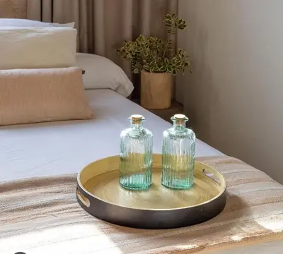 two glass bottles on a tray on a bed at Hotel Rural El Teular in Sueca