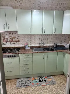 a kitchen with white cabinets and a sink at El Molino Buñol Apartamento in Buñol