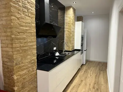a kitchen with a black counter top and a refrigerator at Valdeolivas Suites in Valencia