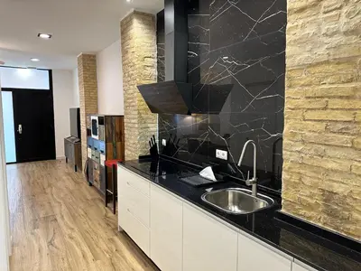 a kitchen with a sink and a black counter top at Valdeolivas Suites in Valencia