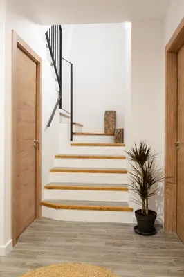 a staircase in a home with white walls and wooden stairs at Mar de fonts ain in Ahín