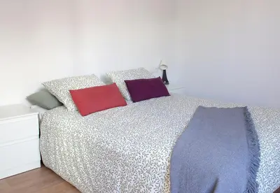 a bedroom with a bed with colorful pillows on it at Mar de fonts ain in Ahín