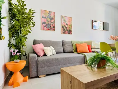a living room with a gray couch with colorful pillows at Sweet Aparment in Russafa (Soho) in Valencia