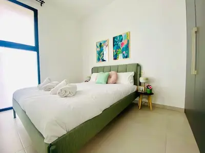 a bedroom with a green bed with towels on it at Sweet Aparment in Russafa (Soho) in Valencia