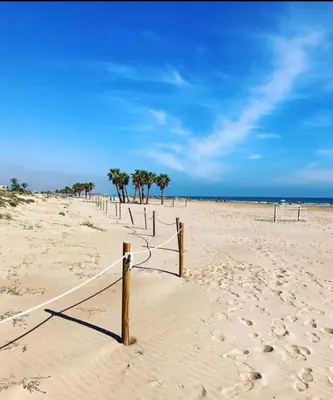 a beach with a volleyball net in the sand at Big Gran Khan Apartment Canet den Berenguer con Piscina in Canet de Berenguer