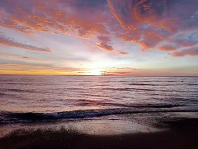 a sunset on the beach with the ocean at Big Gran Khan Apartment Canet den Berenguer con Piscina in Canet de Berenguer