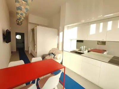 a kitchen with a red table and white cabinets at CariSan2 - fully equipped, 6 min to beach in Valencia