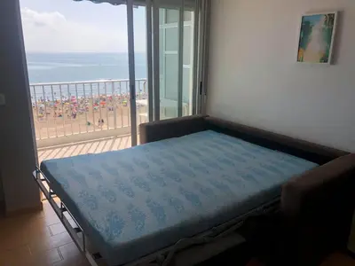 a bed in a room with a view of the beach at Vistas espectaculares 