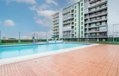 an empty swimming pool in front of a building at Beautiful Apartment In Cullera in Cullera