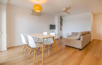 a living room with a table and chairs and a couch at Beautiful Apartment In Cullera in Cullera