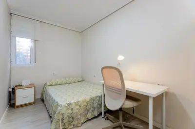 a bedroom with a bed and a desk and a desk at Acogedor apartamento en Valencia cerca de la playa in Valencia