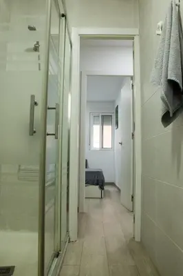 a bathroom with a walk in shower and a bedroom at Precioso apartamento en Malvarrosa Playa Valencia in Valencia
