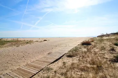 a boardwalk in the sand at the beach at Global Vacacional, Bonito apartamento en Puerto Sagunto para parejas in Puerto de Sagunto