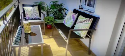 a balcony with two benches with pillows and plants at Apartamento en la montaña, Serra in Serra