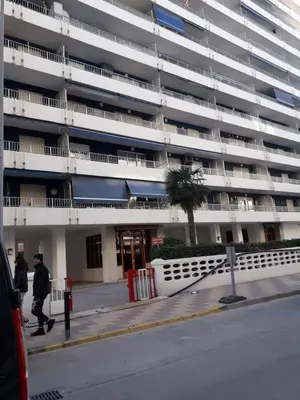 two people walking in front of a large building at Apartamento Cullera a 200 metros playa San Antonio con parking in Cullera