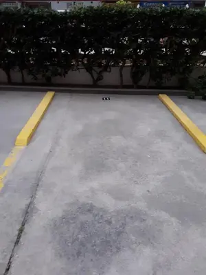 an empty parking lot with yellow lines and plants at Apartamento Cullera a 200 metros playa San Antonio con parking in Cullera