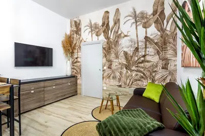 a living room with a wall mural of palm trees at Casa Maravillosa in Valencia