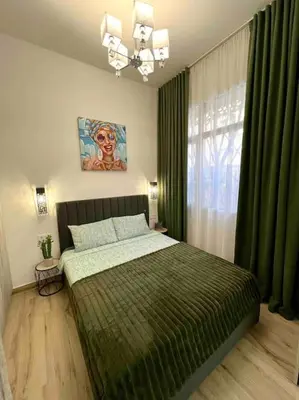 a bedroom with a bed with green sheets and a window at Casa Maravillosa in Valencia