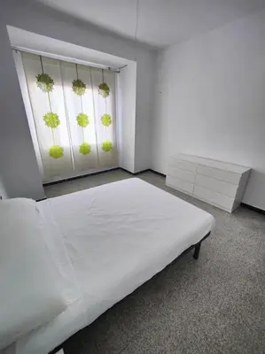 a white room with a bed and a window at Casa de pueblo grande para 7 personas in Corbera de Alcira