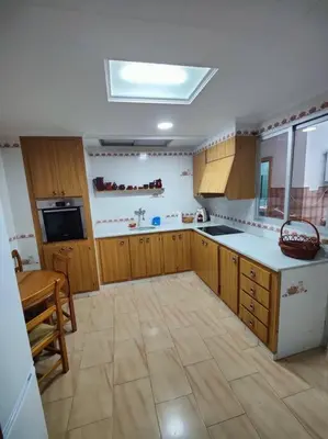 a large kitchen with wooden cabinets and a large floor at Casa de pueblo grande para 7 personas in Corbera de Alcira