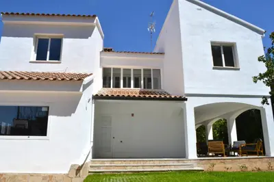 a white house with a garage at Gran Chalet con Piscina (8-10 pp) in La Eliana