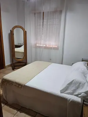 a bedroom with a large bed and a mirror at Ca Vicent in Estivella