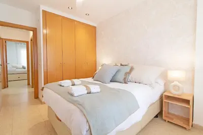 a bedroom with a large bed with towels on it at Global Vacacional, Apartamento con piscina y terraza en la playa de Canet in Canet de Berenguer