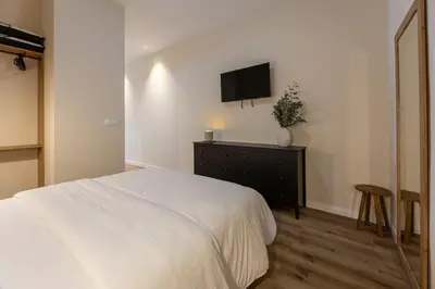 a bedroom with a bed and a tv on the wall at Pivote Flats - Marina B in Valencia